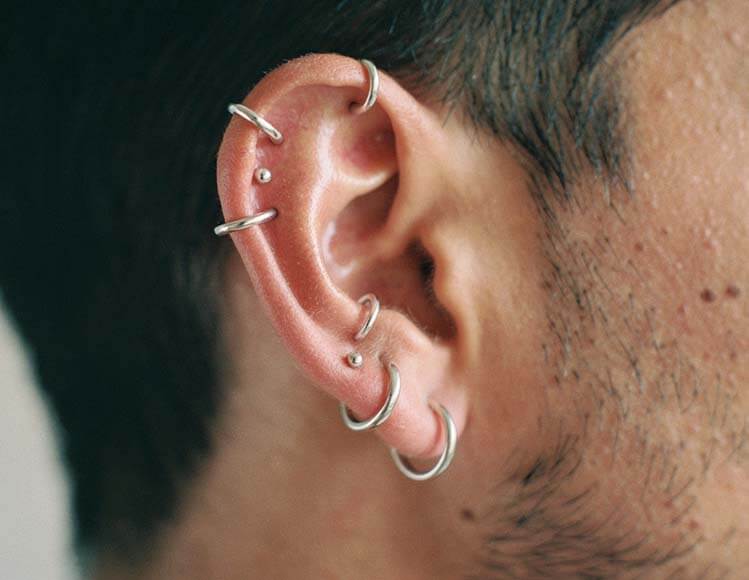 Pose d'un piercing à l'aiguille dans un salon de piercing à Paris